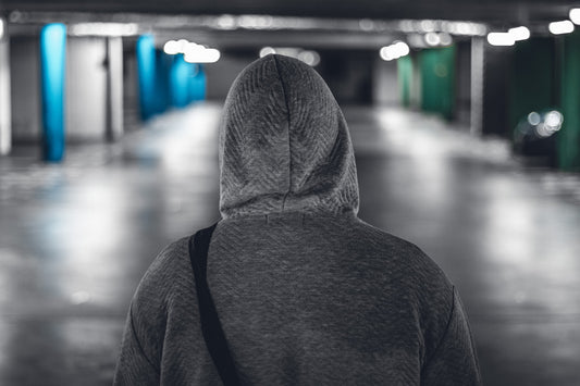 Hoodie Title Image Man Wearing a Grey Hoodie in a Parking Garage