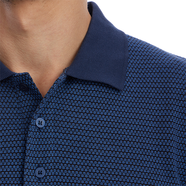 Close-up of a person wearing a blue patterned polo shirt with a white background