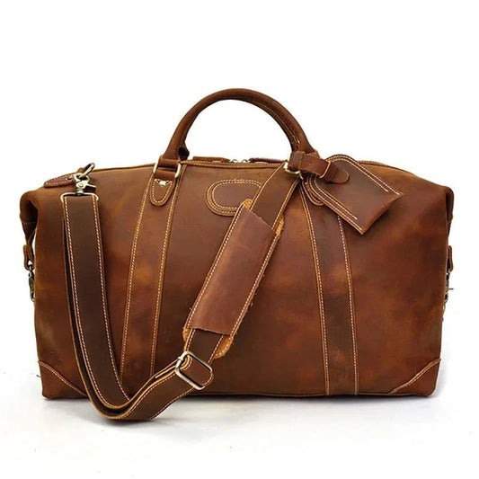 Vintage leather duffle bag in brown with shoulder strap and front tab detail.