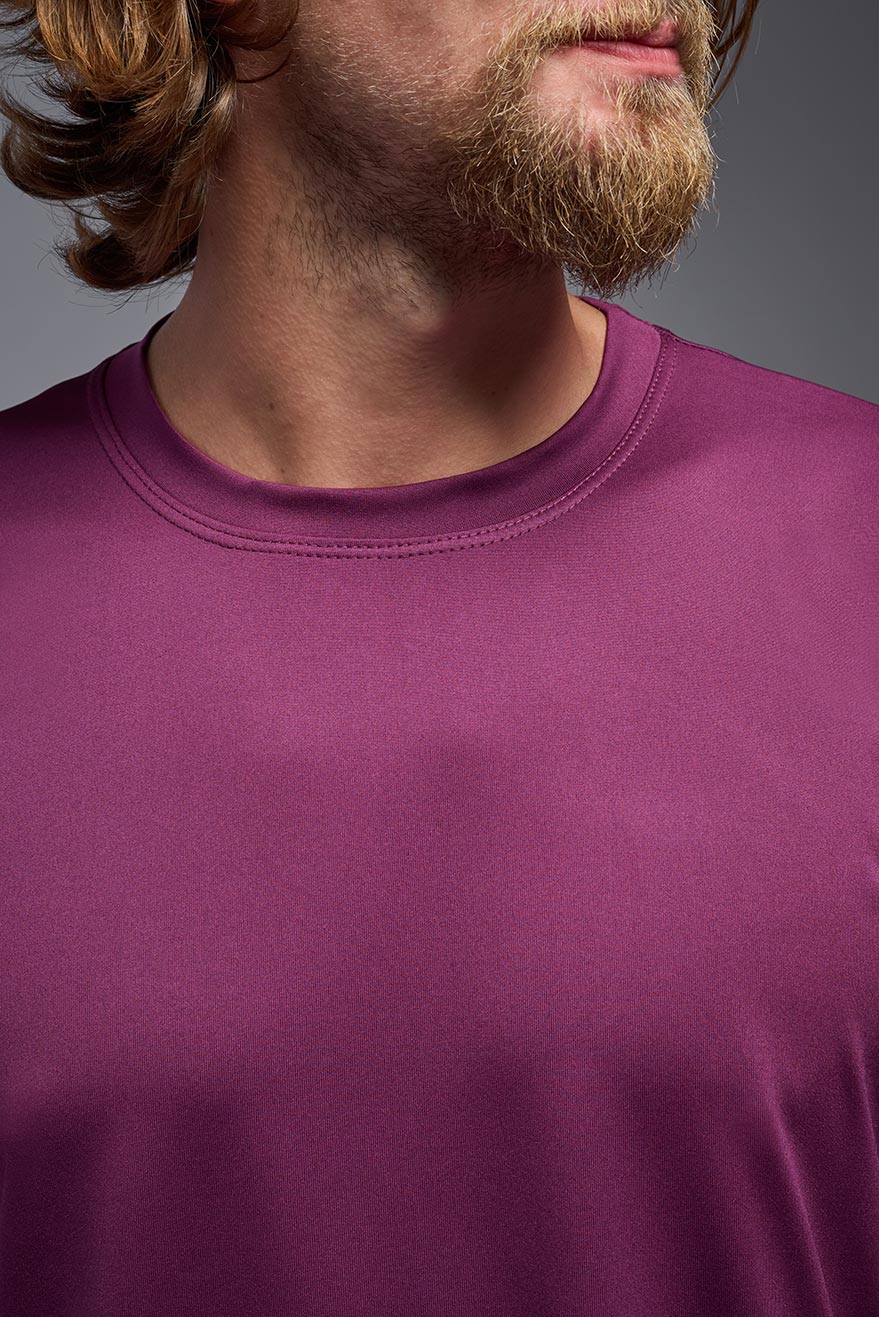 Close-up of a person wearing a purple shirt with a neutral background