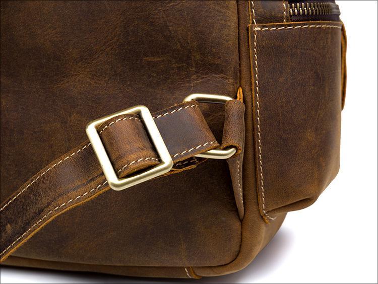 Vintage leather backpack side detail with metal buckle, stitched panel and strap