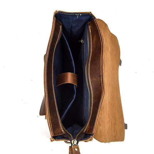Vintage leather backpack open to reveal dark interior lining and zip-side trim