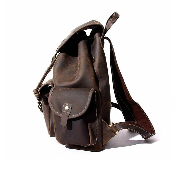 Dark brown leather rucksack with side pocket, front flap pouch, and adjustable shoulder strap