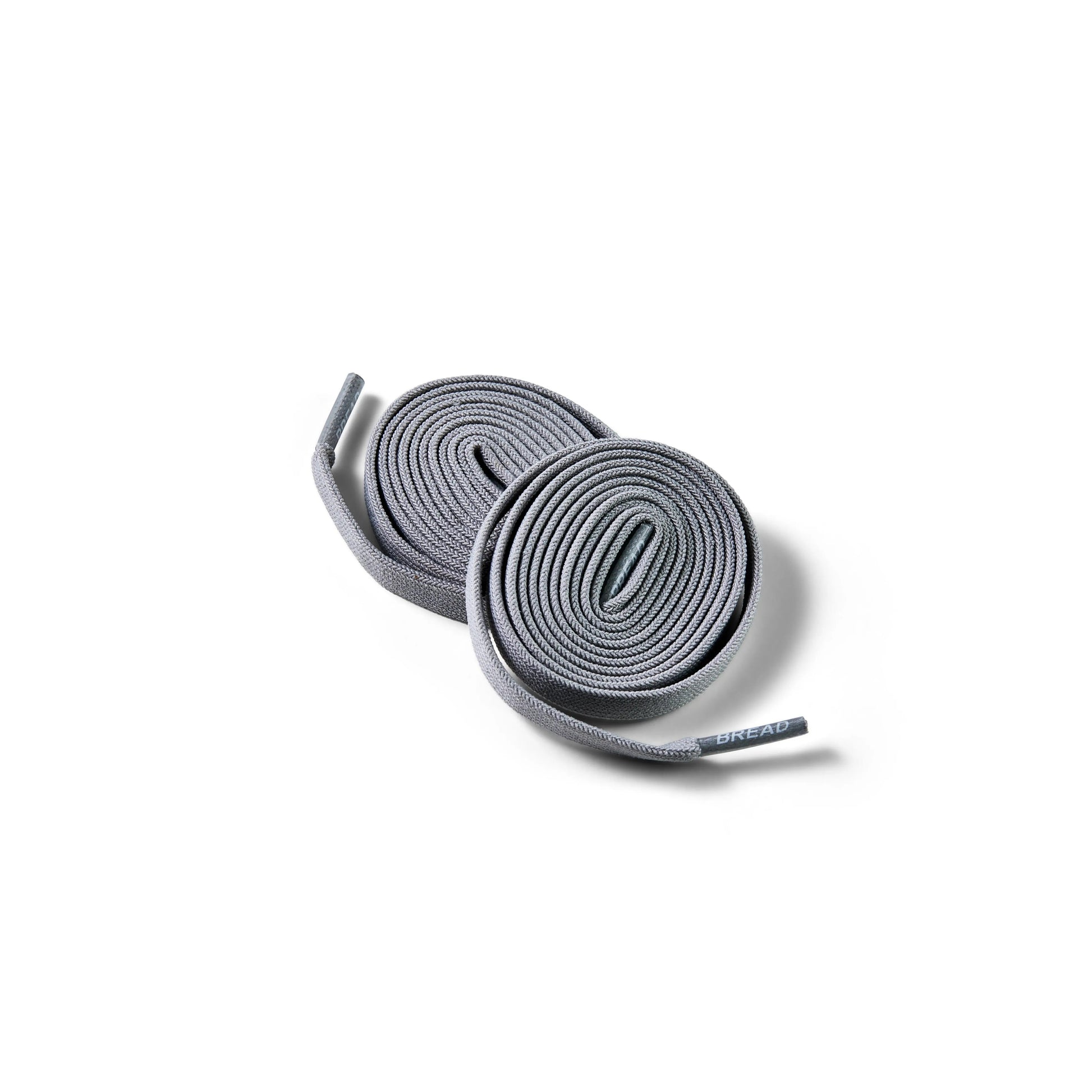 Two pairs of gray shoelaces on a white background