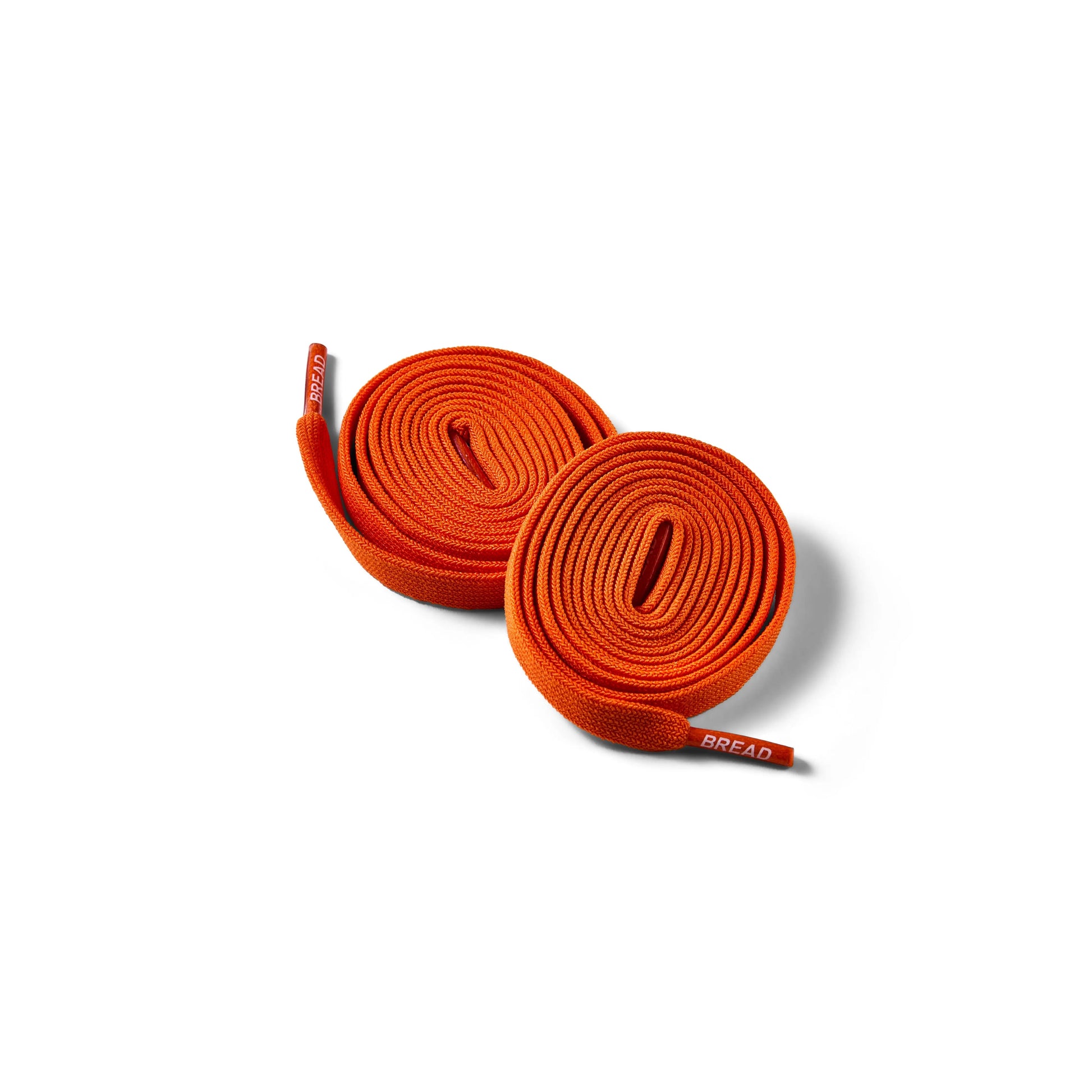 Pair of orange shoelaces on a white background