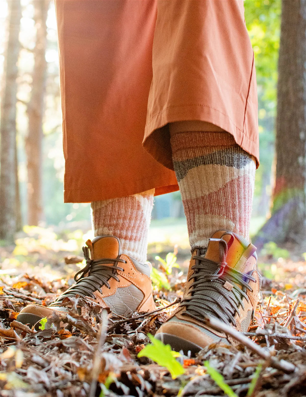Person wearing hiking boots and colorful socks in a forest setting