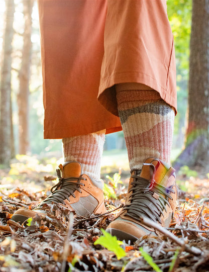 Person wearing hiking boots and colorful socks in a forest setting