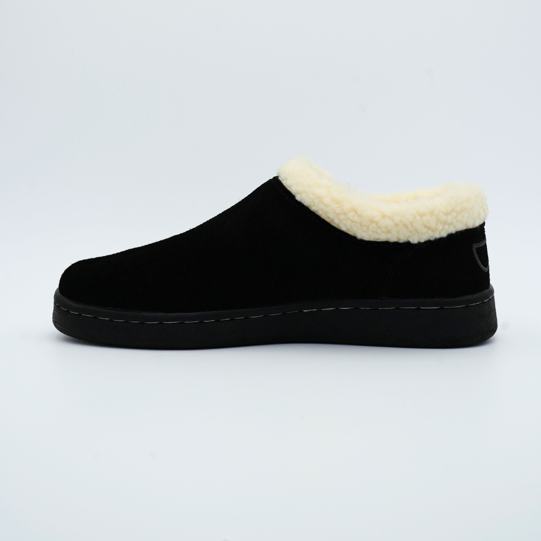Black slip-on shoe with white fur lining on a light gray background