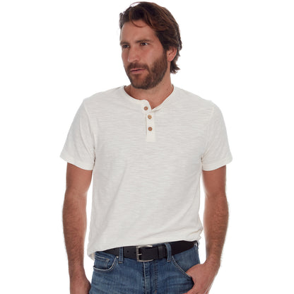 Man wearing a white henley shirt with brown buttons and blue jeans on a white background