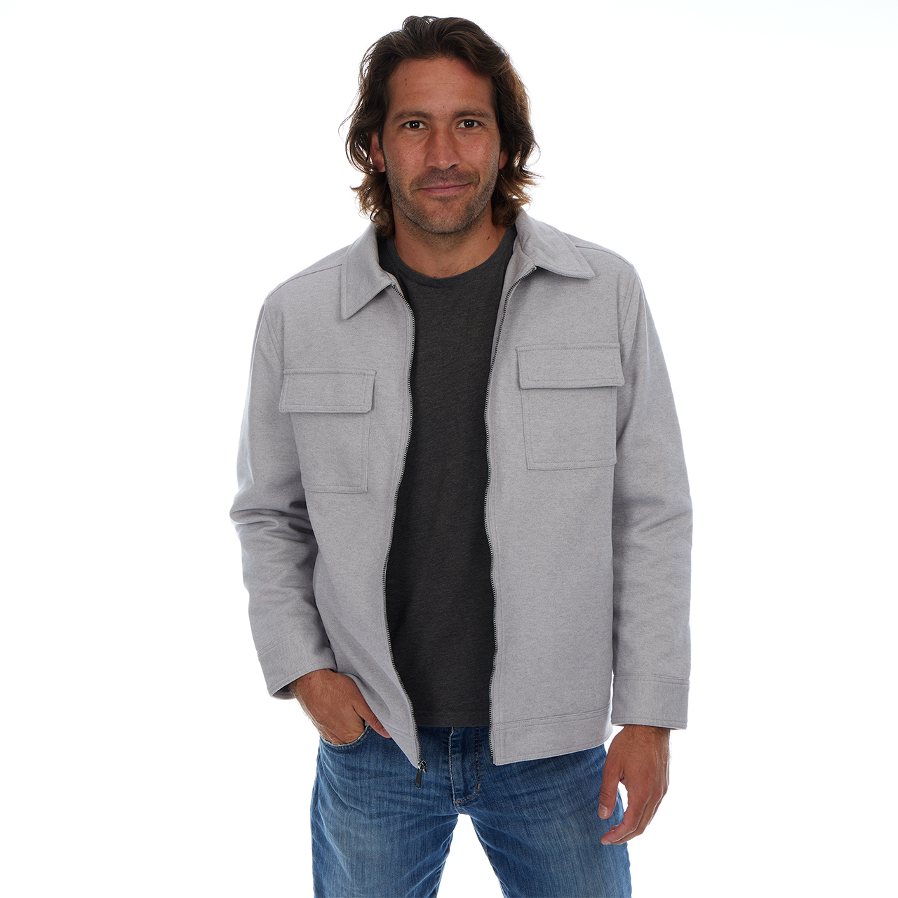 Man wearing a gray jacket over a black shirt with blue jeans on a white background