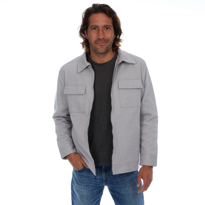 Man wearing a gray jacket over a black shirt with blue jeans on a white background