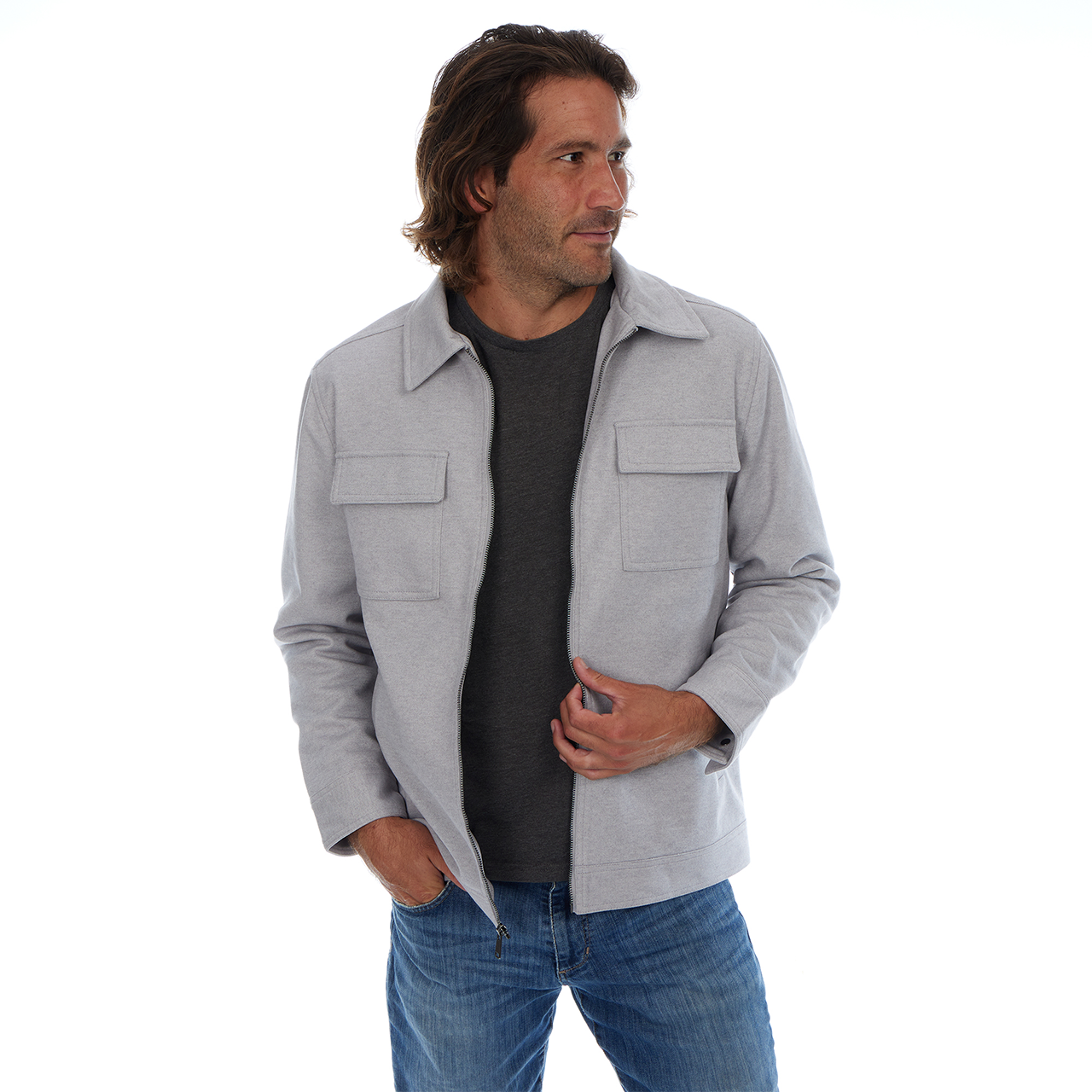 Man wearing a gray jacket over a black shirt and blue jeans on a white background
