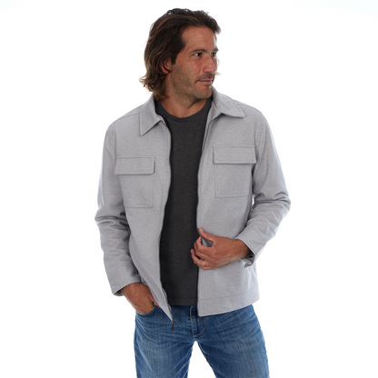 Man wearing a gray jacket over a black shirt and blue jeans on a white background