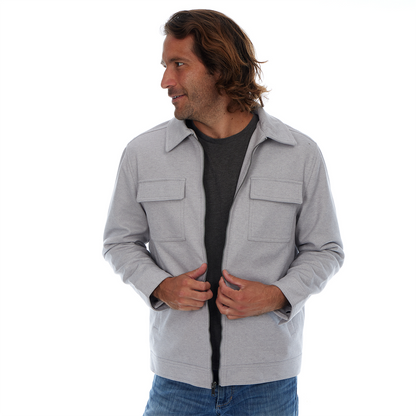 Man wearing a gray jacket over a black shirt on a white background