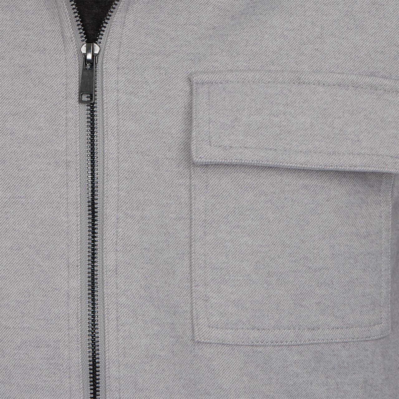 Close-up of a gray jacket with a zipper and pocket
