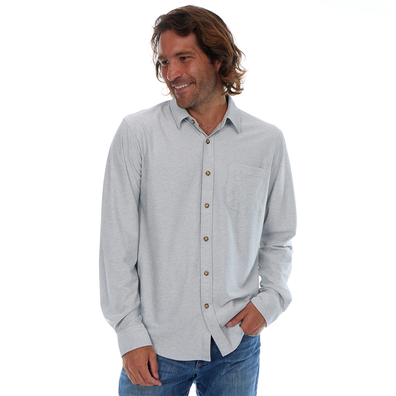 Man wearing a light gray button-up shirt with blue jeans on a white background