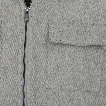 Close-up of a gray textured fabric with a zipper and pocket
