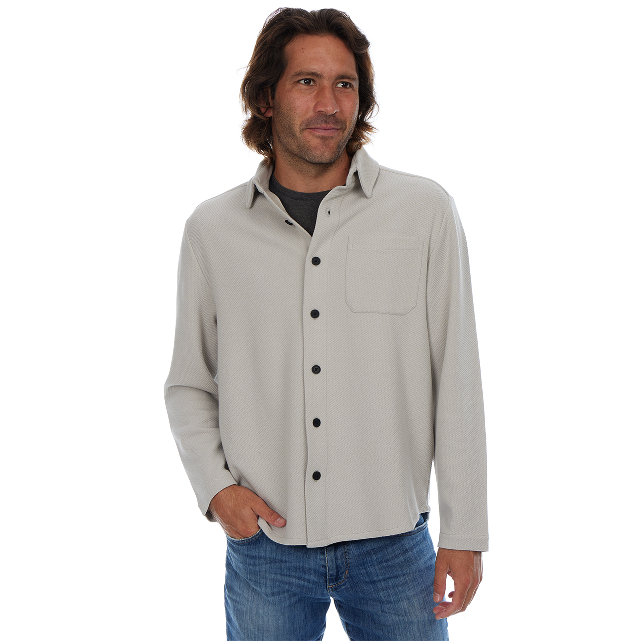 Man wearing a light gray button-up shirt and blue jeans on a white background