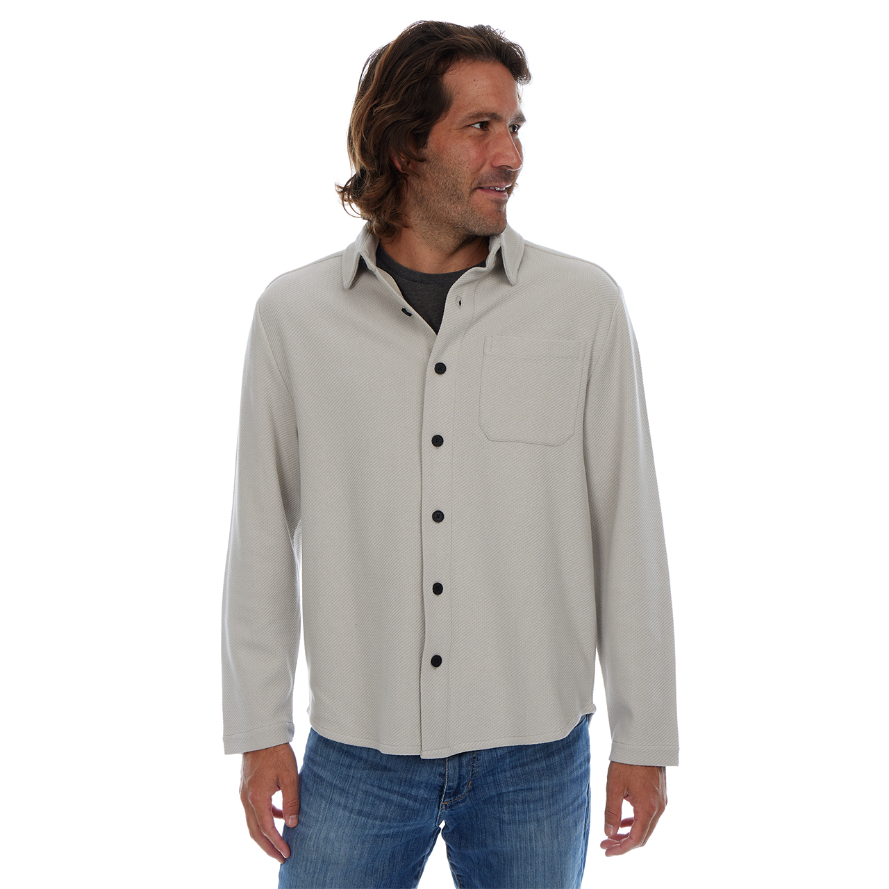 Man wearing a light gray button-up shirt with black buttons on a white background