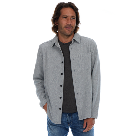 Man wearing a gray button-up shirt over a black t-shirt on a white background