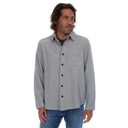 Man wearing a gray button-up shirt with black buttons on a white background