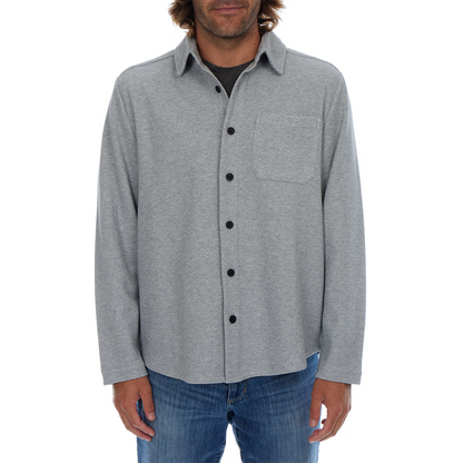 Man wearing a gray button-up shirt with a white background