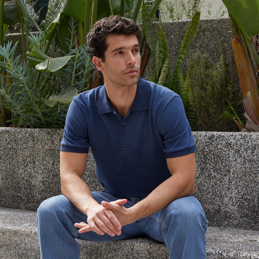 Man sitting outdoors with plants in the background