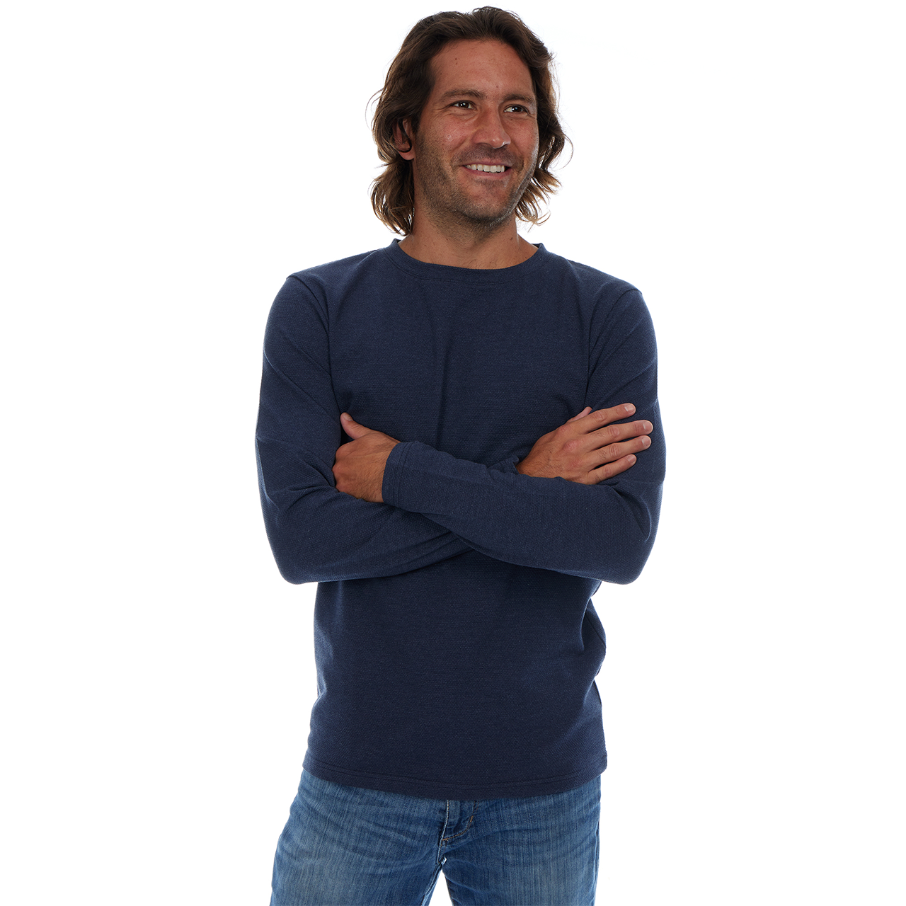 Man wearing a navy blue sweater and jeans on a white background