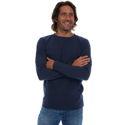 Man wearing a navy blue sweater and jeans on a white background