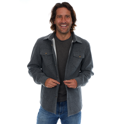 Man wearing a gray jacket over a dark shirt on a white background