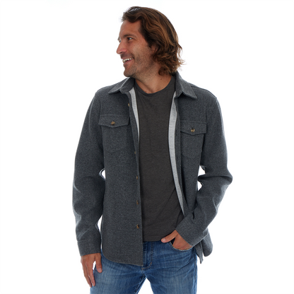 Man wearing a gray jacket over a dark shirt with a white background