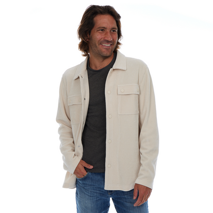 Man wearing a beige jacket over a black shirt on a white background