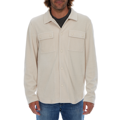Man wearing a beige button-up shirt with a white background