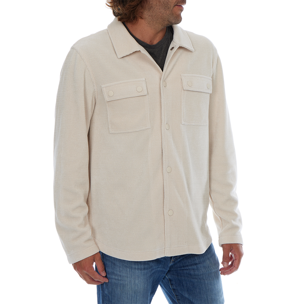 Man wearing a beige button-up shirt with two front pockets on a white background