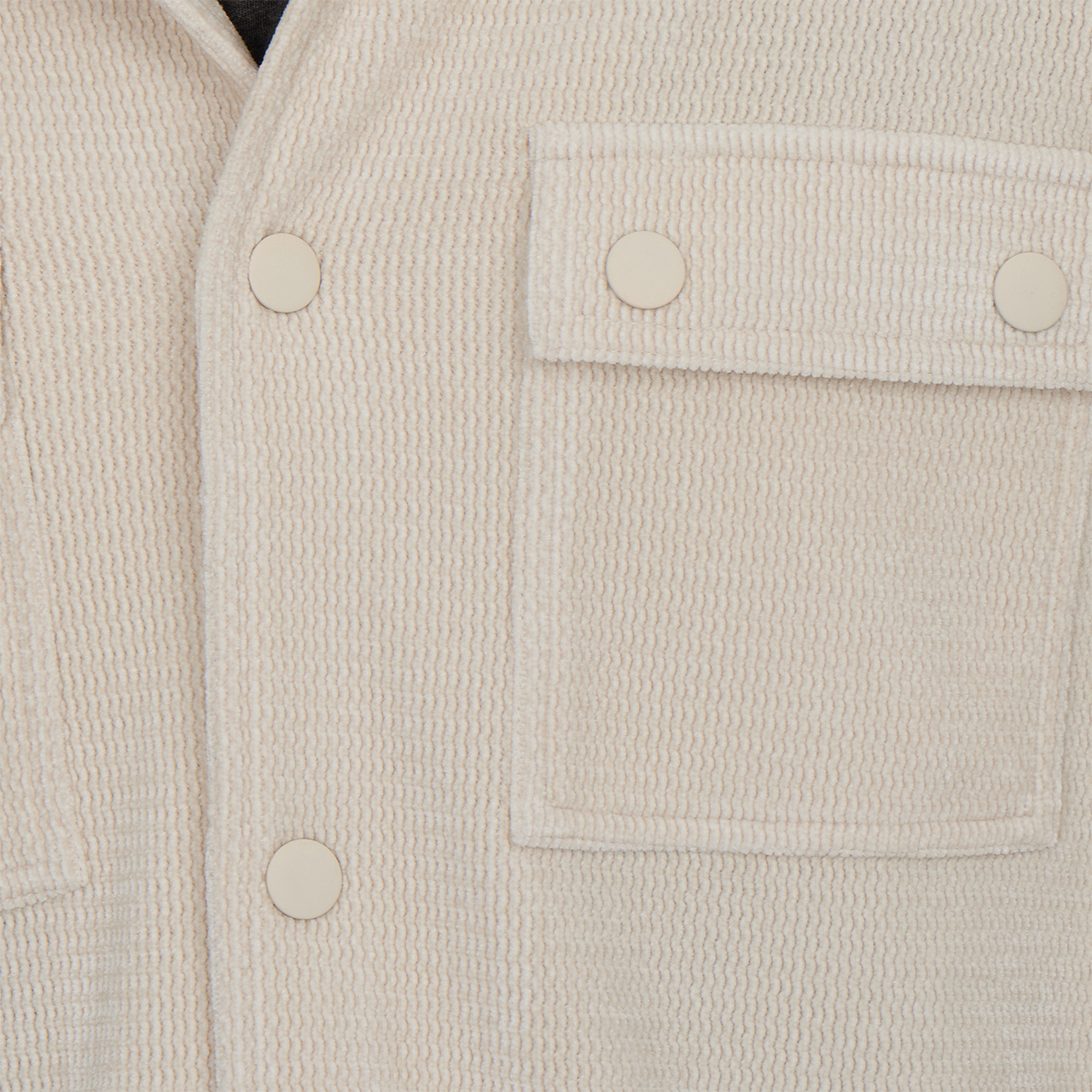 Close-up of a beige textured jacket with button details
