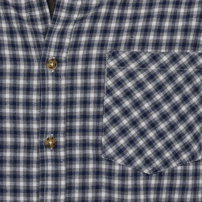 Close-up of a blue and white checkered shirt with buttons and a pocket.