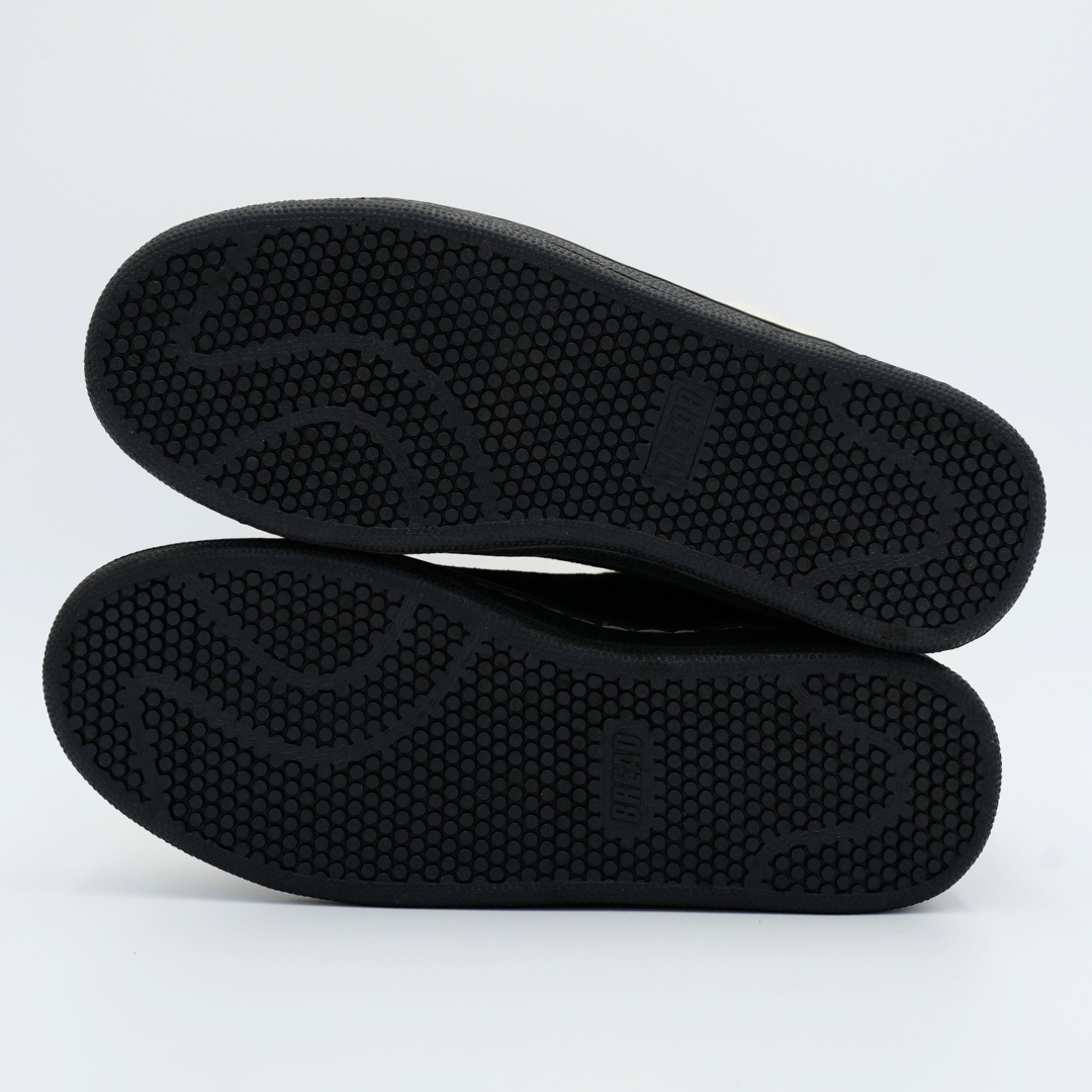 Black shoe soles on a light gray background