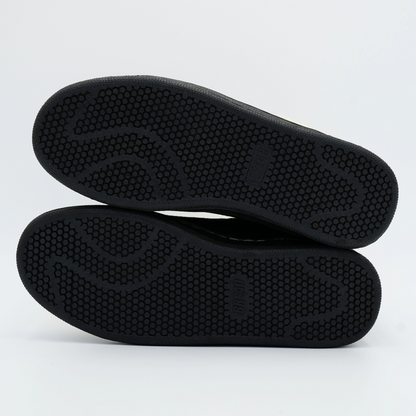 Black shoe soles on a light gray background