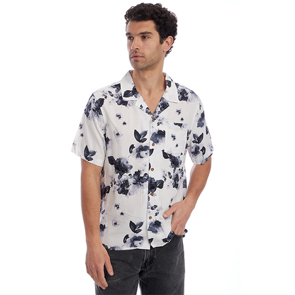 Man wearing a white shirt with black floral pattern on a white background