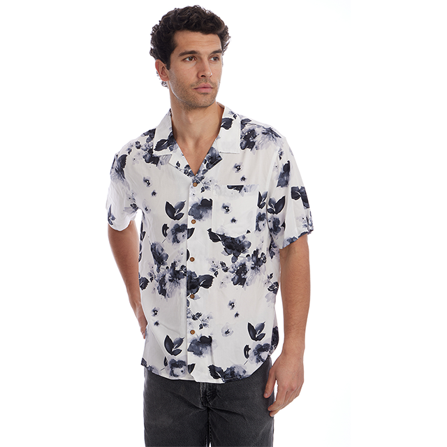 Man wearing a white shirt with black floral pattern on a white background