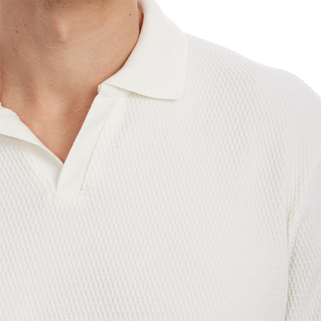 Close-up of a person wearing a textured white shirt with a collar.