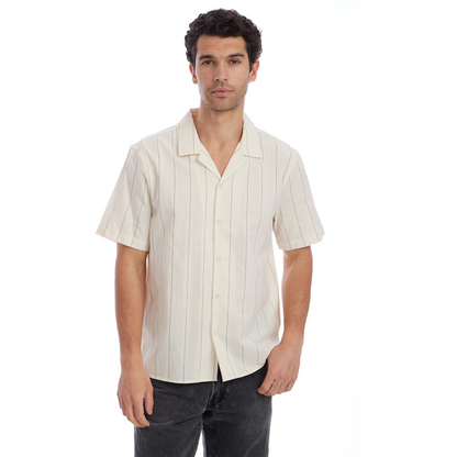 Man wearing a cream-colored short-sleeve shirt with vertical stripes on a white background