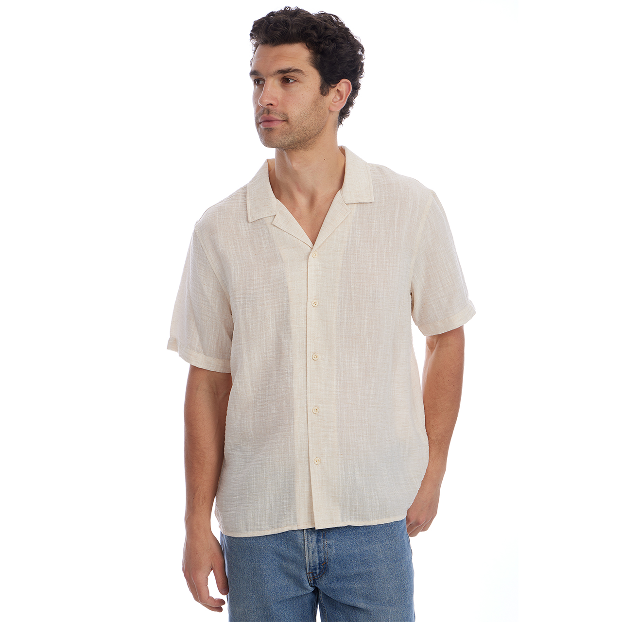 Man wearing a beige short-sleeve shirt and blue jeans on a white background