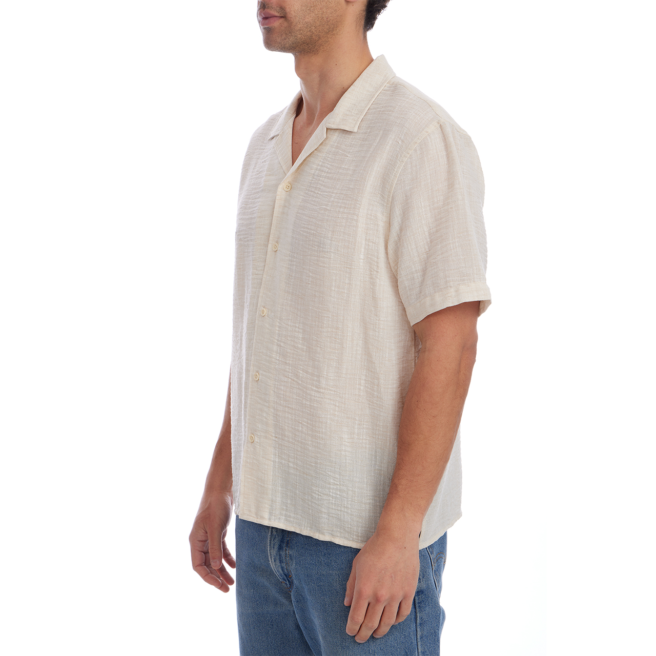 Man wearing a beige short-sleeve shirt and blue jeans on a white background