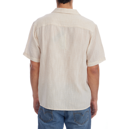 Person wearing a beige short-sleeve shirt on a white background