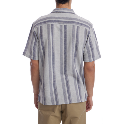 Person wearing a striped shirt and beige pants on a white background
