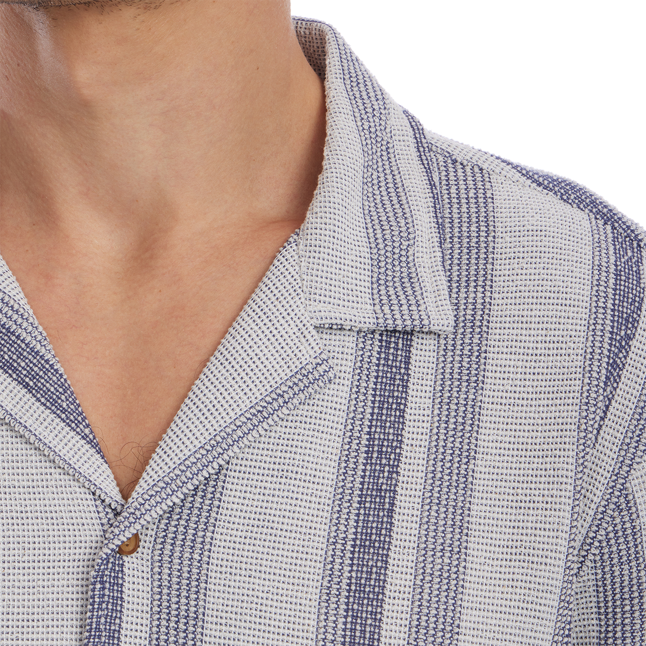 Close-up of a person wearing a textured shirt with a collar.