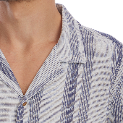 Close-up of a person wearing a textured shirt with a collar.