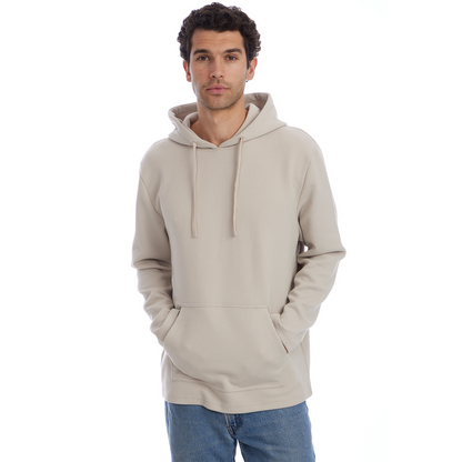 Man wearing a beige hoodie and blue jeans on a white background