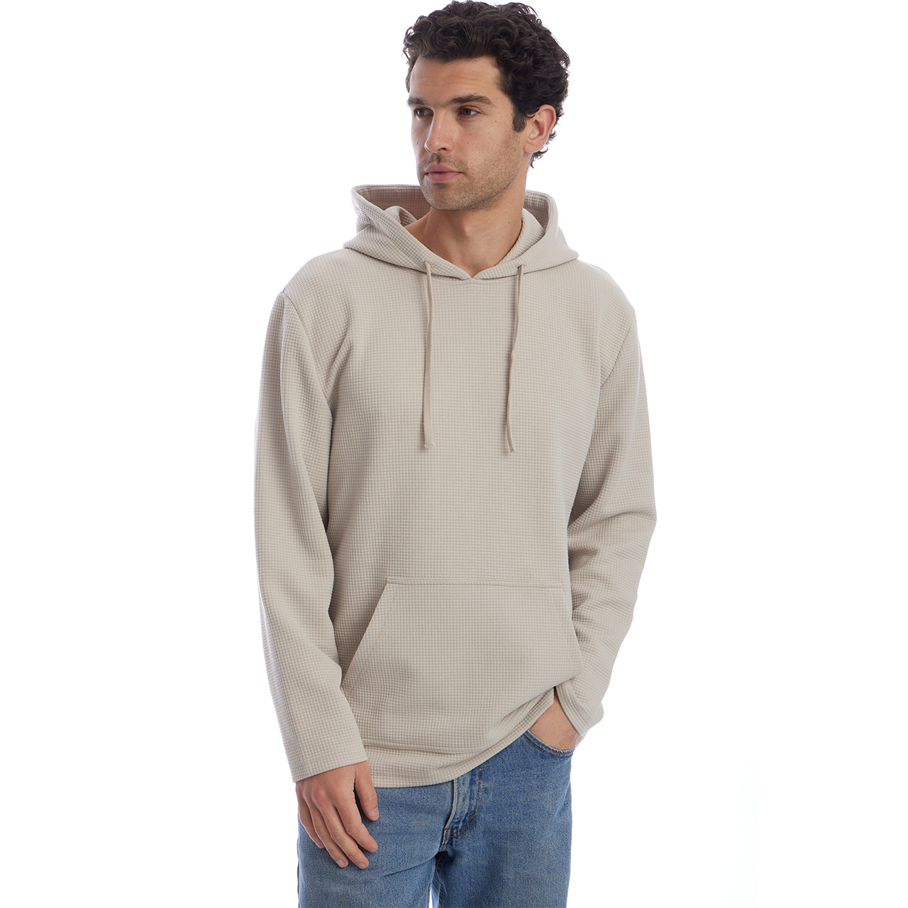 Man wearing a beige hoodie and blue jeans on a white background